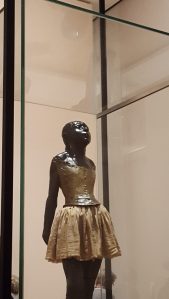 Momento Mori: murdered child ballerina, entombed in her glass case, face to the light. 